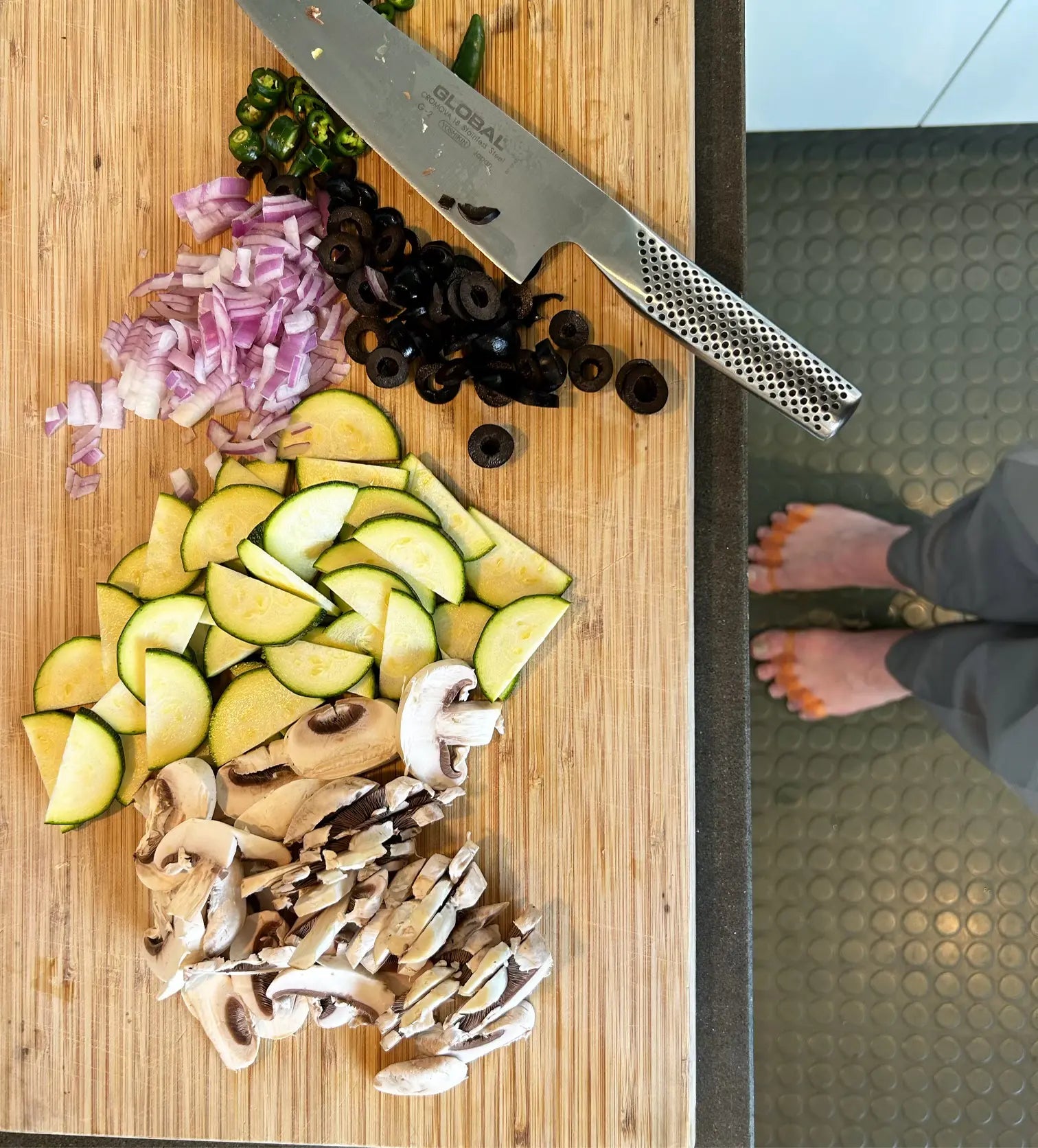 Wearing Tingle Toes toe spacers while chopping vegetables in the kitchen.